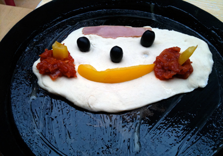 aprendizaje-y-diversion Una carita feliz formada por alimentos en un sartén